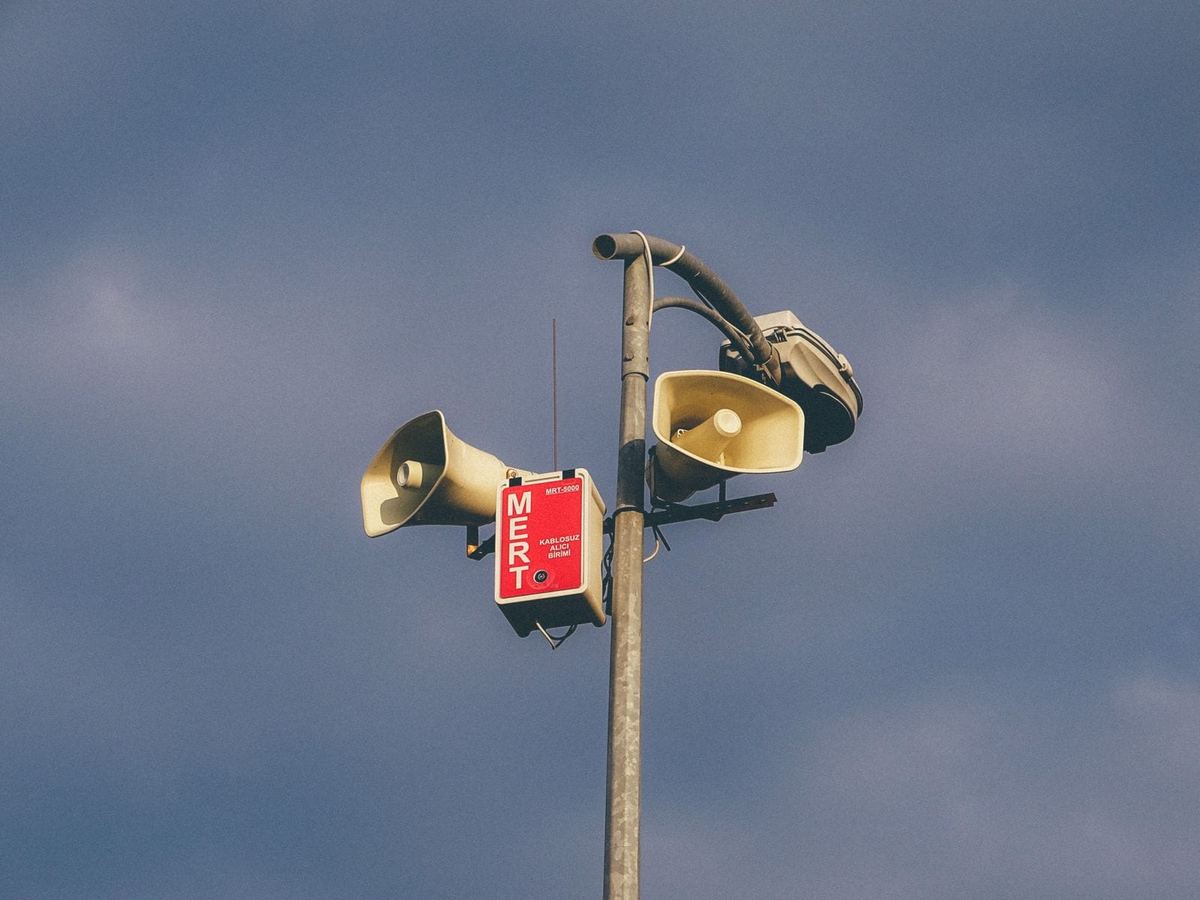 Warnlautsprecher an einem Mast vor ruhigem Himmel