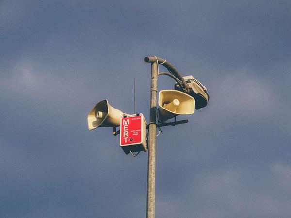 Warnlautsprecher an einem Mast vor ruhigem Himmel